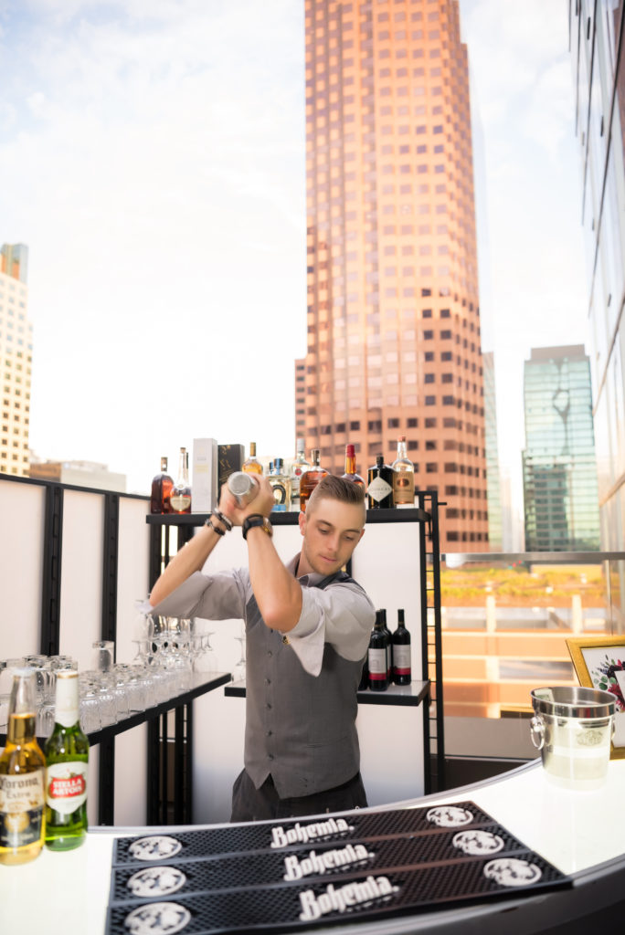 hotel indigo bartender on terrace mixing drink downtown skyline