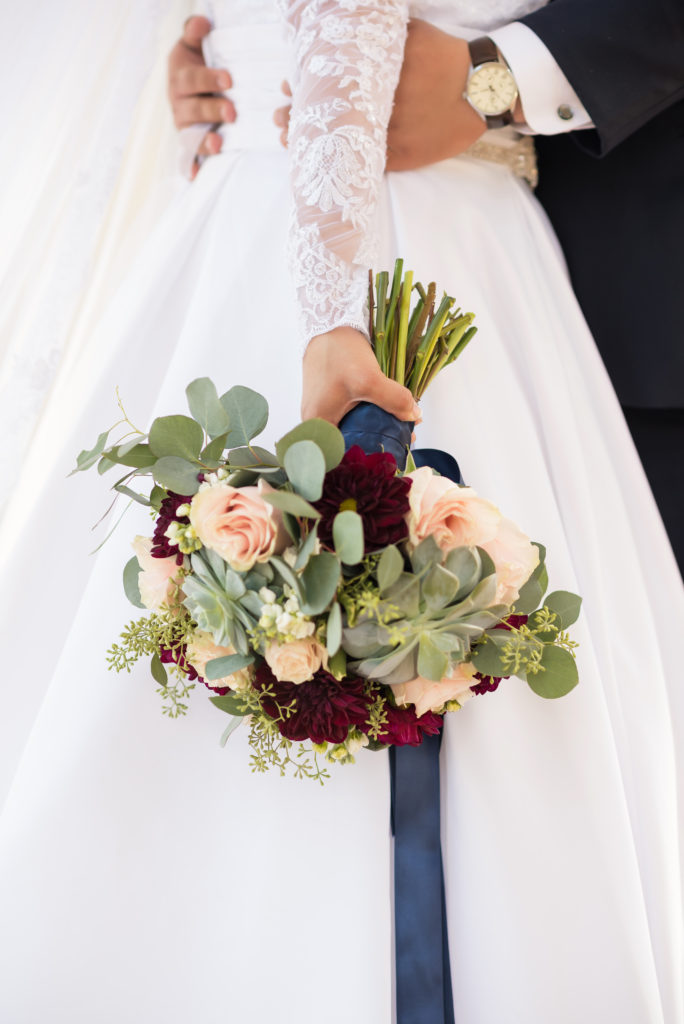 Bride holding navy and blush bouquet