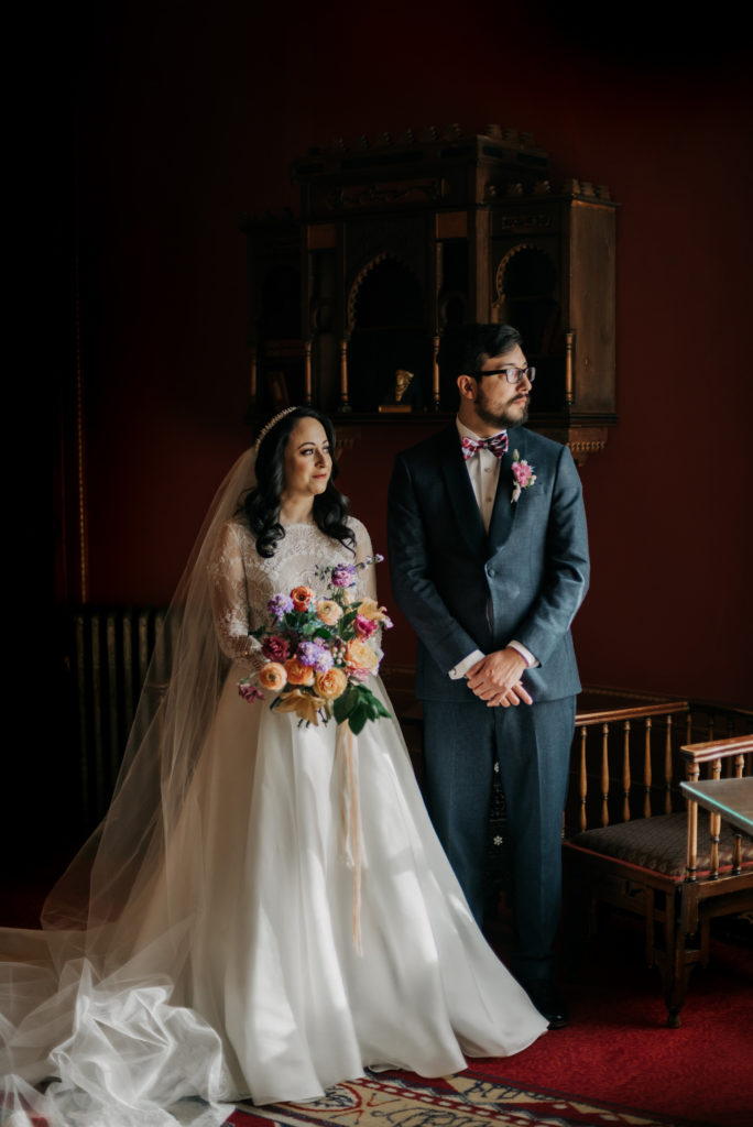 bride and groom in dark room with bouquet